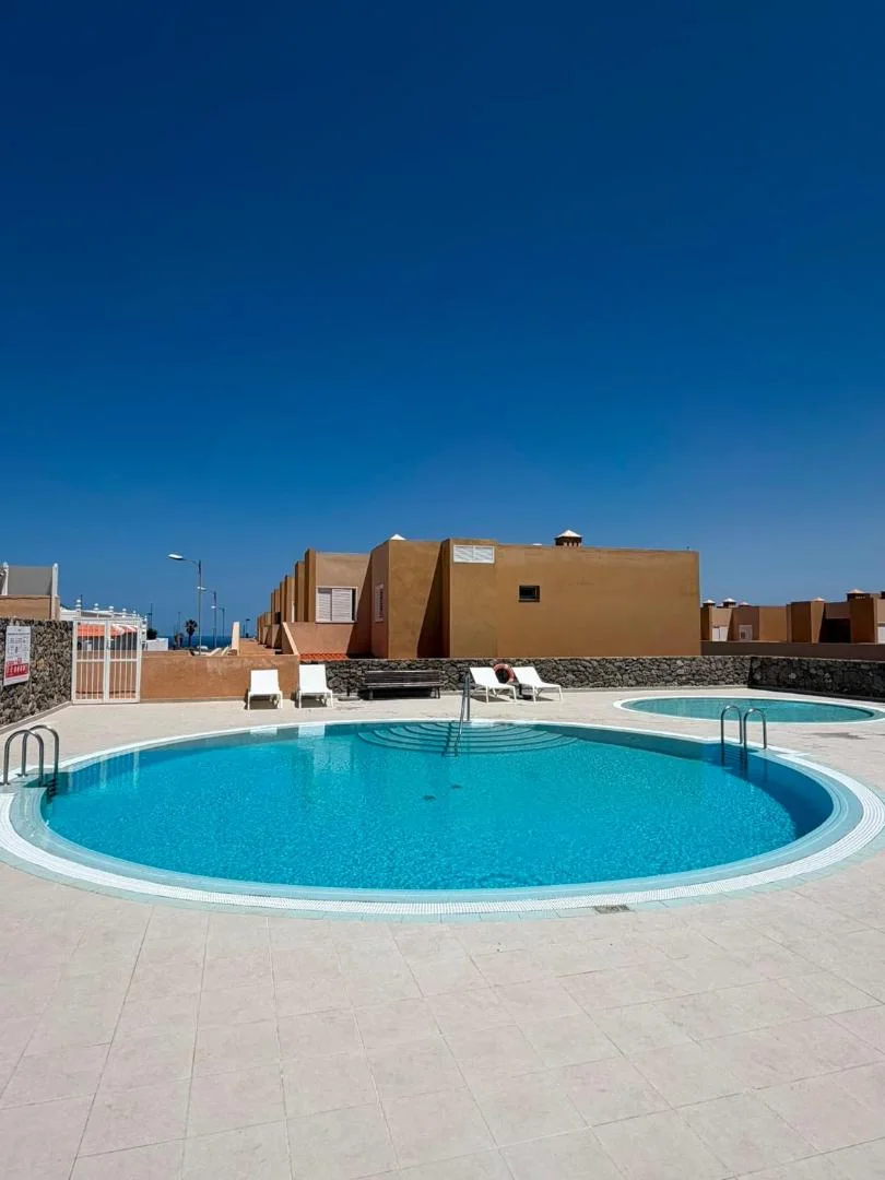 Piscina redonda con tumbonas